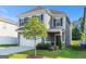 Two-story home featuring stone accents, a two-car garage, a green lawn, and neutral colored siding at 2384 Hastings Manor Ln, Hampton, GA 30228