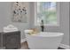 Bright bathroom featuring a modern soaking tub, contemporary fixtures, and a decorative cabinet at 285 Acton Dr, Fayetteville, GA 30215