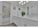 Well-lit bathroom featuring double sinks with chrome faucets, a large mirror and a shower over the tub at 285 Acton Dr, Fayetteville, GA 30215