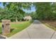 Long private driveway leading to a brick home with a well-manicured lawn and mature trees providing shade at 285 Acton Dr, Fayetteville, GA 30215