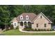Charming brick home featuring a manicured lawn, beautiful landscaping and architectural details including dormer windows at 285 Acton Dr, Fayetteville, GA 30215