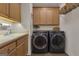 Bright laundry room with sink, wooden cabinets, front-load washer and dryer and overhead storage shelf at 285 Acton Dr, Fayetteville, GA 30215
