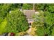 Aerial view of a brick home with mature trees and manicured landscaping at 398 Patrick Henry Ct, Riverdale, GA 30274