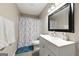 Well-lit bathroom with a shower-tub combination, white vanity, and blue accents at 398 Patrick Henry Ct, Riverdale, GA 30274