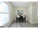 Bright dining room with grey laminate flooring, a marble table, and a picturesque window view at 398 Patrick Henry Ct, Riverdale, GA 30274