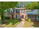 Charming brick townhome with well-maintained lawn, walkway, and mature shade trees at 398 Patrick Henry Ct, Riverdale, GA 30274