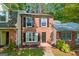 Well-kept two-story brick townhome featuring a walkway and tidy landscaping at 398 Patrick Henry Ct, Riverdale, GA 30274