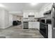 Well-lit kitchen features stainless appliances, white cabinets, and views to living room at 398 Patrick Henry Ct, Riverdale, GA 30274