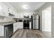 Bright kitchen features stainless appliances, white cabinets, and updated fixtures at 398 Patrick Henry Ct, Riverdale, GA 30274