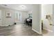 Open-concept living room featuring grey laminate flooring, a dining table and a view into the attached bathroom at 398 Patrick Henry Ct, Riverdale, GA 30274