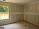 Unfinished bedroom featuring a window with natural light and unfinished flooring at 5555 Hwy 155 N, Stockbridge, GA 30281
