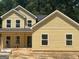 Newly constructed two-story home with bright yellow siding, showcasing a classic and inviting design at 5555 Hwy 155 N, Stockbridge, GA 30281