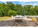 Large backyard patio with white table and bench, grill, and view of the beautiful wooded yard at 195 Berry Hill Ln, Tyrone, GA 30290