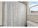 Close up of bathroom featuring toilet and shower with white shower curtain next to window at 195 Berry Hill Ln, Tyrone, GA 30290