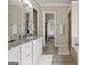 Bathroom featuring double sinks, granite countertops, and a view into a walk-in closet at 195 Berry Hill Ln, Tyrone, GA 30290