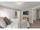 Bright bedroom with comfortable bedding, a television, closet, and an adjacent room visible through the doorway at 195 Berry Hill Ln, Tyrone, GA 30290