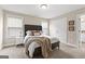Well-lit bedroom features a bed with stylish linens, a nightstand, and a glimpse of the en-suite bathroom at 195 Berry Hill Ln, Tyrone, GA 30290
