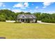 Craftsman-style home with gray siding, stone accents, a well-manicured lawn, and lush trees at 195 Berry Hill Ln, Tyrone, GA 30290