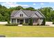 Charming craftsman-style home with gray siding, stone accents, a manicured lawn and a well-kept front yard at 195 Berry Hill Ln, Tyrone, GA 30290