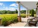 Cozy front porch with stone columns, comfortable seating, and a view of the beautifully landscaped front yard at 195 Berry Hill Ln, Tyrone, GA 30290