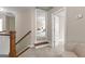 Hallway with wooden staircase, neutral walls, carpet flooring, and an adjacent room visible through the doorway at 195 Berry Hill Ln, Tyrone, GA 30290