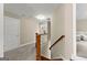 Second floor hallway featuring carpet, wood banister, and view of a bedroom and living room at 195 Berry Hill Ln, Tyrone, GA 30290