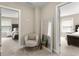 Hallway with a comfortable chair, mirror, and views into adjacent bedrooms with neutral decor at 195 Berry Hill Ln, Tyrone, GA 30290