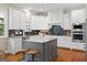 Modern kitchen featuring white cabinets, granite countertops, stainless steel appliances, and a stylish kitchen island at 195 Berry Hill Ln, Tyrone, GA 30290