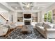 Spacious living room with coffered ceilings, built-in shelves, a stone fireplace, and modern furnishings at 195 Berry Hill Ln, Tyrone, GA 30290