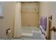 Neutral colored bathtub with shower, floral wallpaper, and chrome hardware at 2400 White Pine Ln, Mansfield, GA 30055