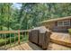 Outdoor deck surrounded by lush greenery, featuring a covered grill and ample space for activities at 2400 White Pine Ln, Mansfield, GA 30055