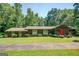 Charming ranch style home with lush greenery and mature trees surrounding the property at 2400 White Pine Ln, Mansfield, GA 30055