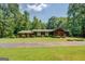 Charming ranch style home with lush greenery and mature trees surrounding the property at 2400 White Pine Ln, Mansfield, GA 30055