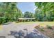 Ranch home featuring a long driveway leading to a well-manicured lawn and mature trees surrounding the property at 2400 White Pine Ln, Mansfield, GA 30055