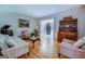 Spacious living room with hardwood floors, vintage furniture, and natural light streaming through the windows at 2400 White Pine Ln, Mansfield, GA 30055