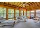 Bright sunroom with wood ceiling and walls of windows showcasing the surrounding nature at 2400 White Pine Ln, Mansfield, GA 30055