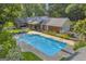Aerial view of a backyard showcasing a large swimming pool, covered patio, and lush landscaping at 603 Lakewood Dr, Social Circle, GA 30025