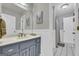 Well-lit bathroom with a blue vanity, spacious mirror, and tiled floors at 603 Lakewood Dr, Social Circle, GA 30025