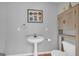 Bathroom featuring a pedestal sink, artwork hanging on the wall, and a toilet at 603 Lakewood Dr, Social Circle, GA 30025