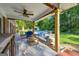 Inviting covered patio with ceiling fan, comfortable seating, and view of the pool and lush backyard at 603 Lakewood Dr, Social Circle, GA 30025