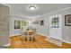 Bright dining room with a round wooden table set and large windows offering natural light at 603 Lakewood Dr, Social Circle, GA 30025