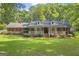 Charming brick home featuring a welcoming front porch with white railings and meticulously landscaped yard at 603 Lakewood Dr, Social Circle, GA 30025