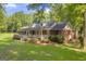 A beautiful single-Gathering home with lush green lawns, mature trees, and a charming covered front porch at 603 Lakewood Dr, Social Circle, GA 30025