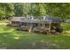 Charming brick home features a welcoming front porch, well-manicured lawn and mature trees, creating a serene setting at 603 Lakewood Dr, Social Circle, GA 30025