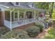 Charming covered porch with rocking chairs, American flag, and manicured landscaping offers a cozy outdoor space at 603 Lakewood Dr, Social Circle, GA 30025