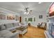 Open-concept living room with a large bay window, fireplace, neutral walls, and hardwood floors at 603 Lakewood Dr, Social Circle, GA 30025