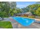 Sparkling swimming pool with a diving board, surrounded by lounge chairs, lush landscaping, and a patio area at 603 Lakewood Dr, Social Circle, GA 30025