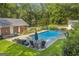 Lush backyard with a refreshing pool, lounge area, and mature trees, perfect for outdoor relaxation at 603 Lakewood Dr, Social Circle, GA 30025