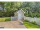 Charming pool shed surrounded by a white picket fence and lush greenery, providing storage at 603 Lakewood Dr, Social Circle, GA 30025