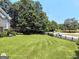 Expansive backyard view with lush green grass, mature trees, and a wooden fence at 1292 Hidden Spirit Trl, Lawrenceville, GA 30045
